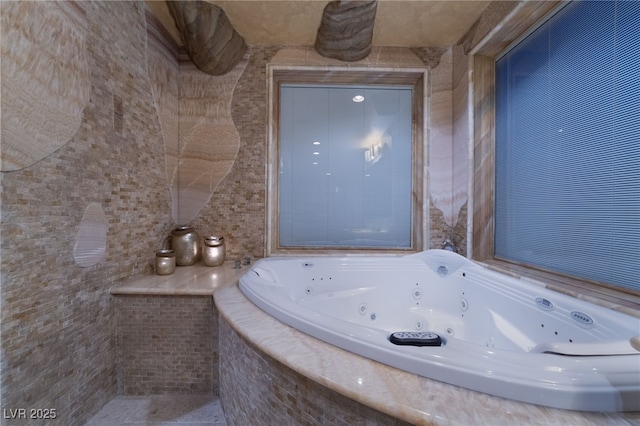 bathroom featuring a whirlpool tub and tile walls