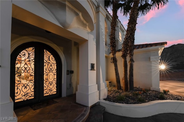 exterior entry at dusk with a tiled roof