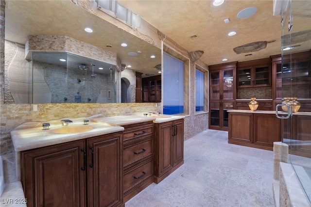 full bath with double vanity, a stall shower, a sink, and recessed lighting