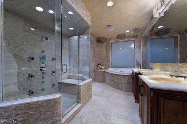 bathroom with a garden tub, recessed lighting, vanity, a shower stall, and stone finish floor