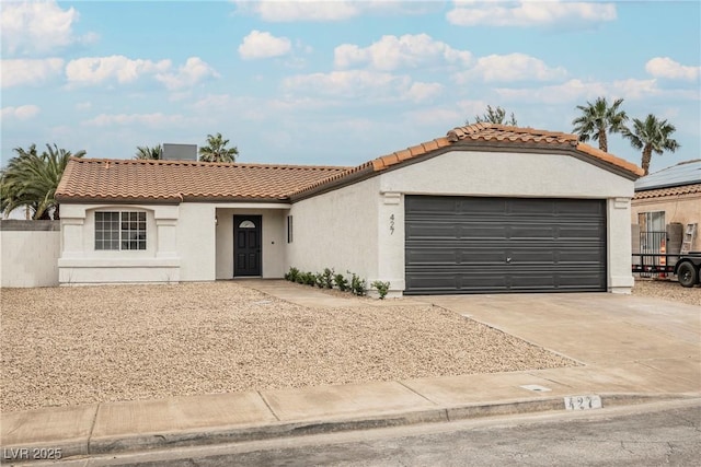 view of front of house with driveway, a tiled roof, an attached garage, and stucco siding