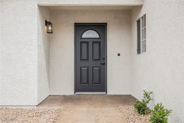 entrance to property featuring stucco siding