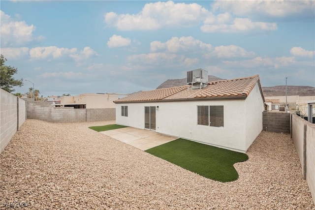 back of property featuring a tile roof, a patio area, a fenced backyard, and stucco siding