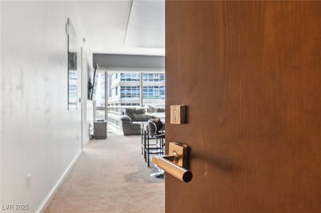 hall featuring carpet flooring and baseboards