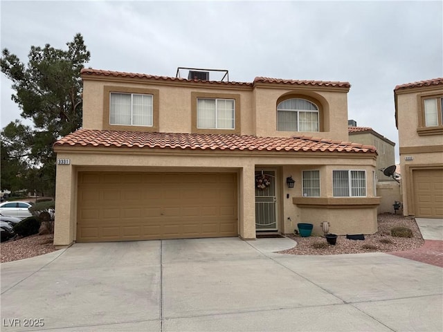 mediterranean / spanish-style home with driveway, an attached garage, and stucco siding