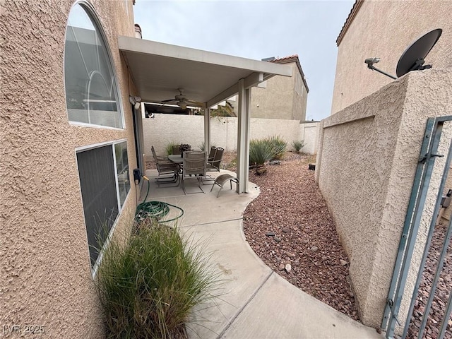 view of patio featuring ceiling fan and fence