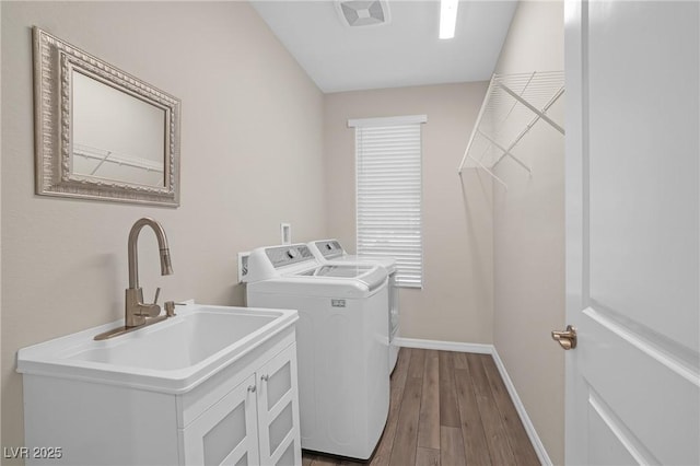 7177 W Camero Ave, Las Vegas, NV 89113 - washroom featuring washing machine and dryer, wood finished floors, visible vents, baseboards, and cabinet space