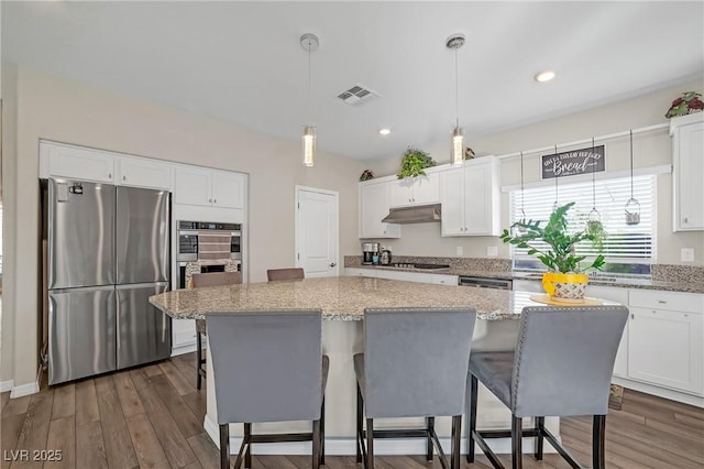 7177 W Camero Ave, Las Vegas, NV 89113 - kitchen with a center island, visible vents, appliances with stainless steel finishes, white cabinetry, and under cabinet range hood