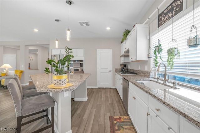 7177 W Camero Ave, Las Vegas, NV 89113 - kitchen featuring a kitchen island, stainless steel appliances, light wood-style floors, white cabinetry, and a sink