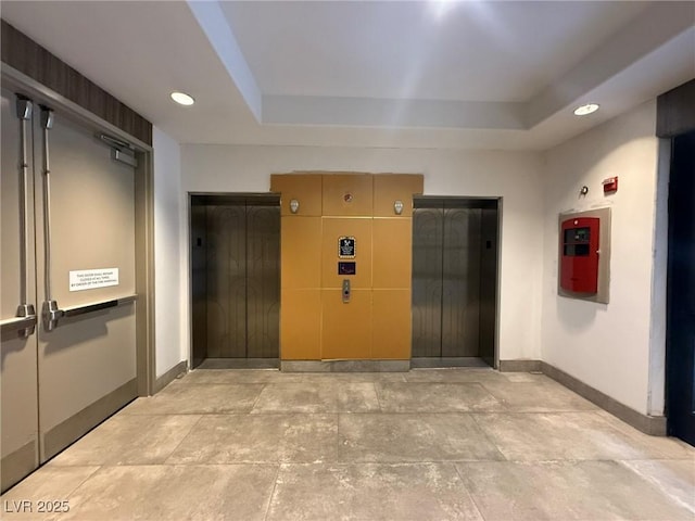 interior space with recessed lighting, elevator, and baseboards