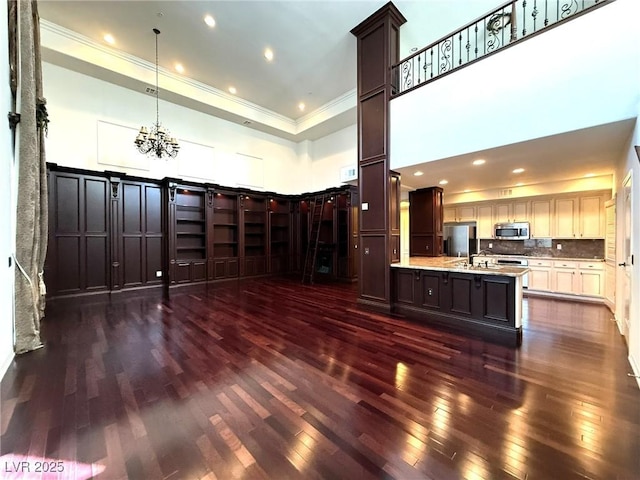 interior space featuring a chandelier, recessed lighting, a high ceiling, dark wood-style flooring, and crown molding