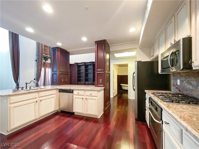 kitchen with dark wood finished floors, stainless steel appliances, recessed lighting, tasteful backsplash, and a sink