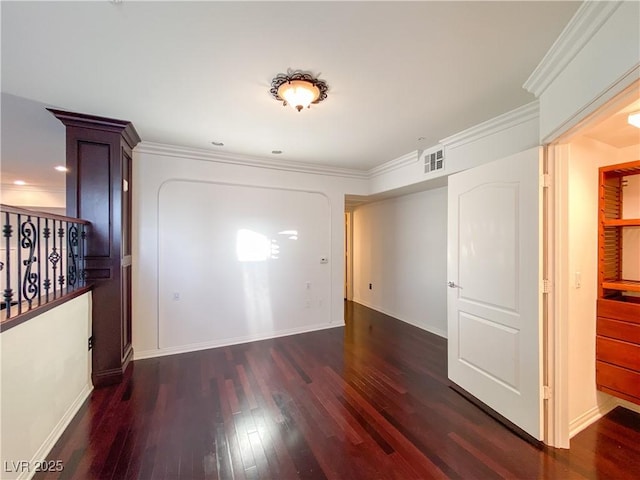 interior space with visible vents, crown molding, baseboards, and wood finished floors