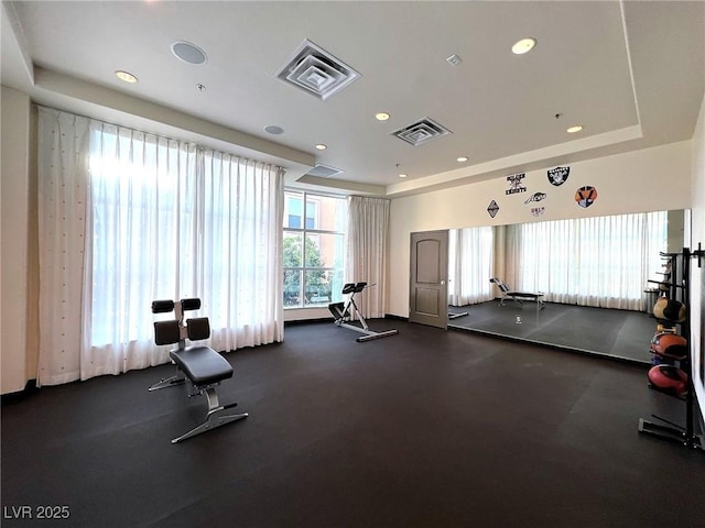 workout area with recessed lighting, a raised ceiling, and visible vents