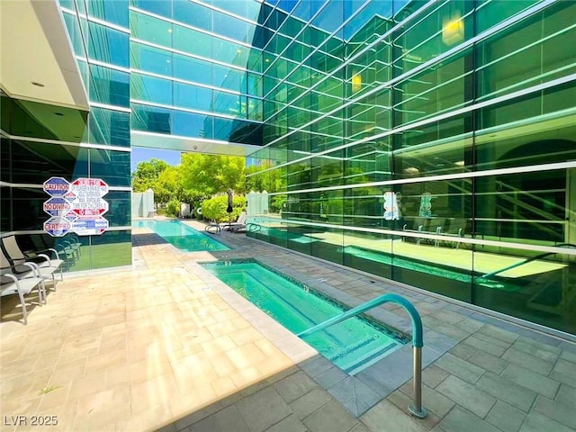 pool featuring a patio and a hot tub