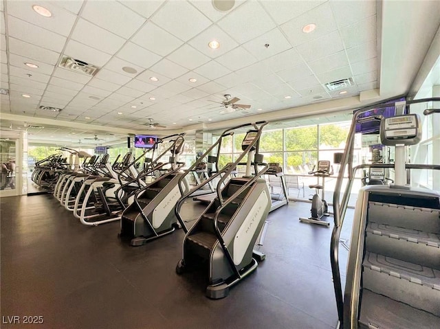 workout area featuring a ceiling fan, a paneled ceiling, and visible vents