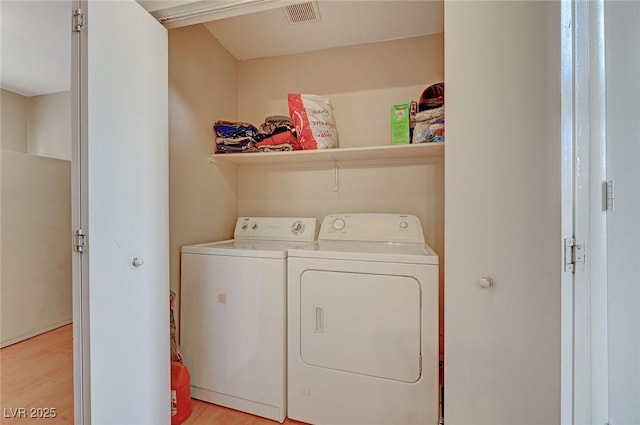 washroom featuring laundry area, visible vents, light wood finished floors, and independent washer and dryer