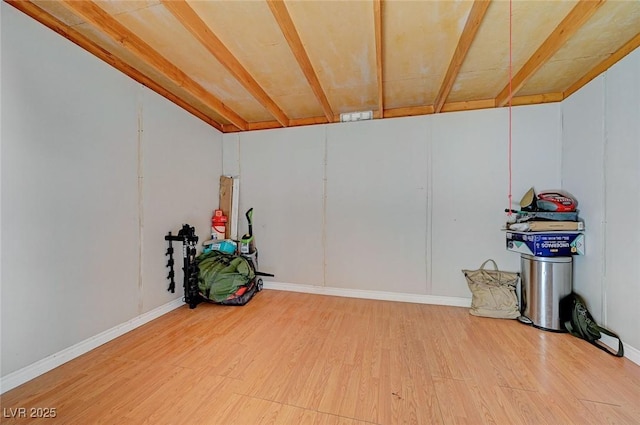 basement featuring baseboards and wood finished floors