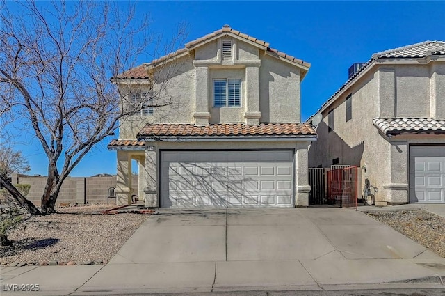 mediterranean / spanish house featuring concrete driveway, a tiled roof, an attached garage, fence, and stucco siding