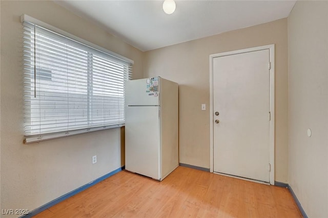 interior space with freestanding refrigerator and light wood finished floors