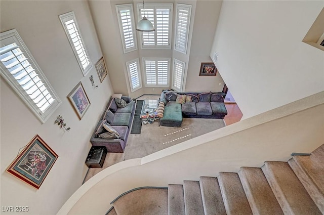 living area with a towering ceiling and stairs