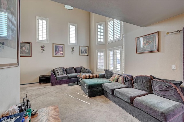 living room featuring carpet floors and a towering ceiling