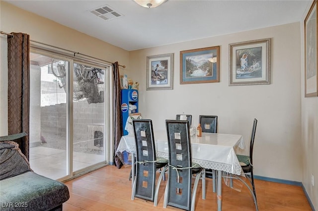 dining area featuring light wood-type flooring, baseboards, and visible vents