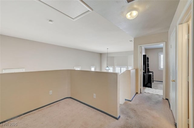 empty room featuring baseboards and light colored carpet