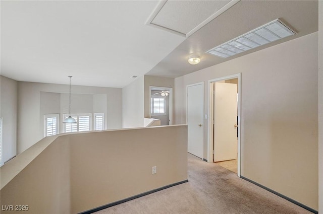 empty room featuring baseboards, visible vents, and light colored carpet