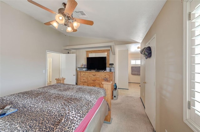 bedroom with vaulted ceiling, ceiling fan, visible vents, and light colored carpet