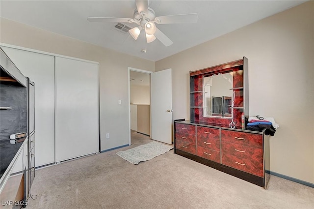 bedroom with light carpet, visible vents, baseboards, ceiling fan, and a closet