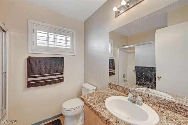 bathroom featuring vanity, an enclosed shower, and toilet