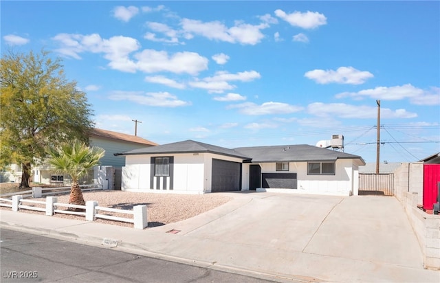 view of front of home featuring a garage, concrete driveway, and a fenced front yard