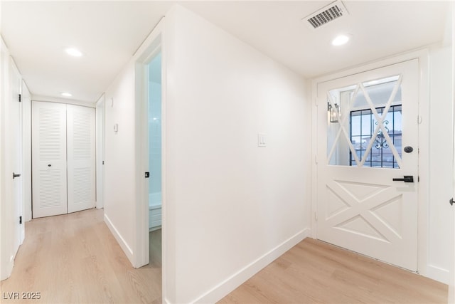 entryway featuring light wood-type flooring, baseboards, and visible vents