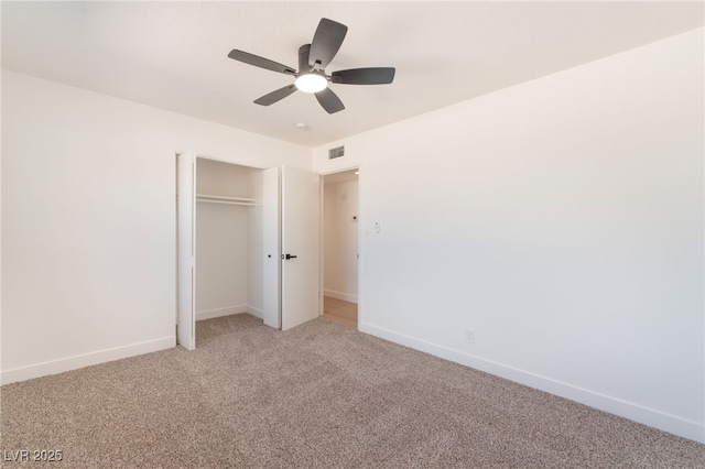 unfurnished bedroom featuring a closet, light colored carpet, visible vents, ceiling fan, and baseboards