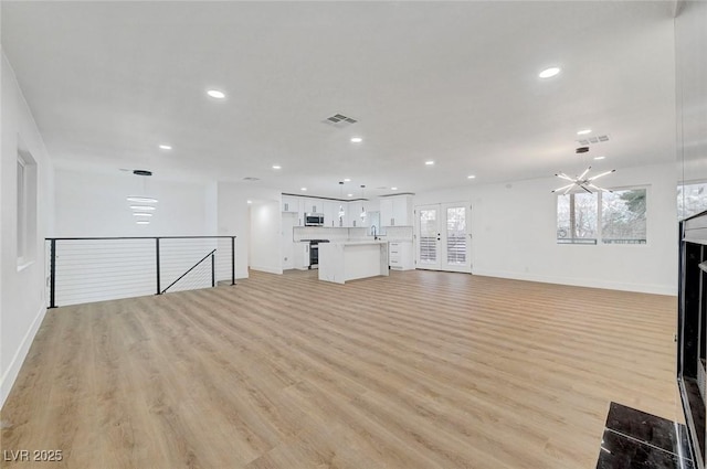 unfurnished living room with baseboards, recessed lighting, visible vents, and light wood-style floors