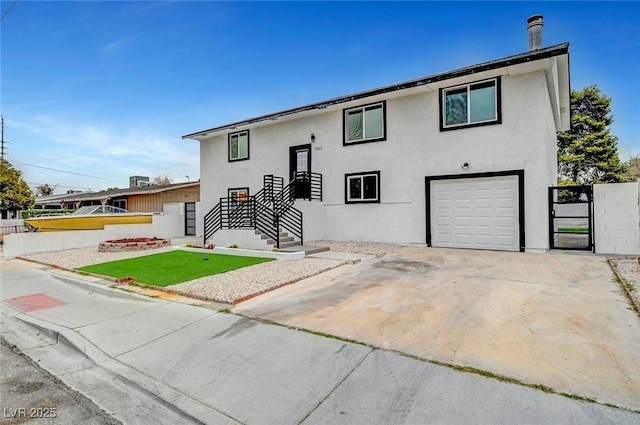 split foyer home with an attached garage, fence, concrete driveway, and stucco siding