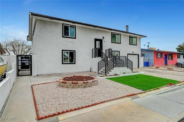 split foyer home with fence, driveway, an attached garage, and stucco siding