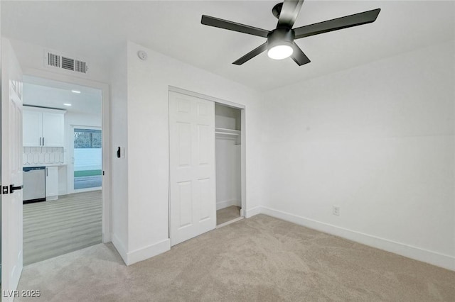 unfurnished bedroom featuring a closet, visible vents, light carpet, ceiling fan, and baseboards