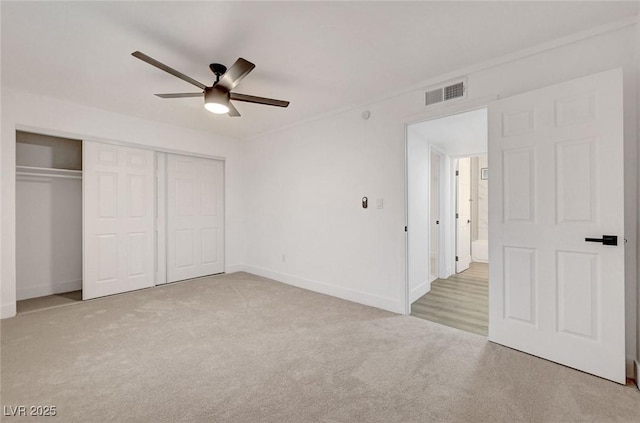 unfurnished bedroom featuring carpet, a closet, visible vents, and ceiling fan