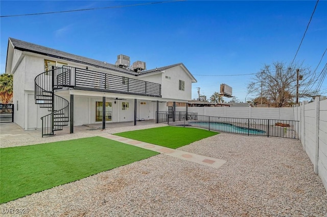 back of house with a fenced in pool, a yard, a patio, a fenced backyard, and stairs