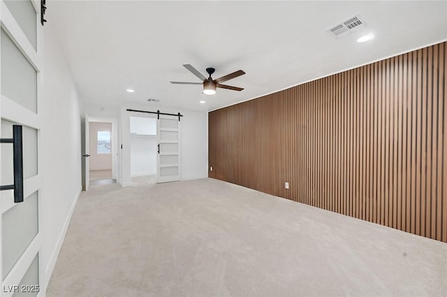 interior space featuring recessed lighting, visible vents, a barn door, a ceiling fan, and carpet flooring