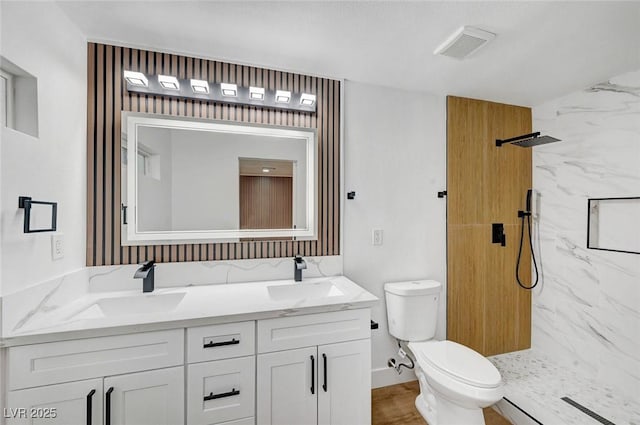 full bathroom featuring toilet, a sink, visible vents, a marble finish shower, and double vanity