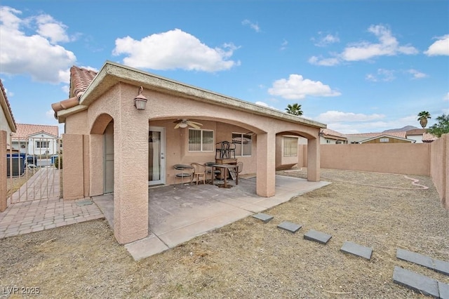 back of property with a tile roof, a patio, stucco siding, a ceiling fan, and a fenced backyard