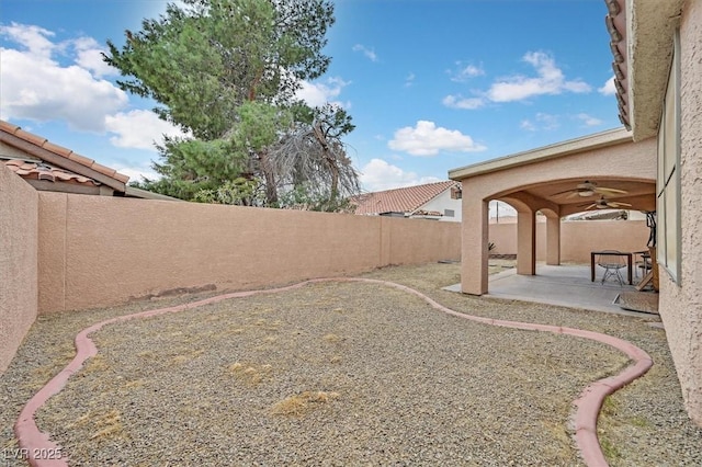 view of yard featuring a fenced backyard, a patio, and ceiling fan