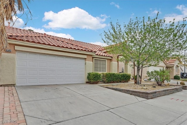 mediterranean / spanish home featuring driveway, a tiled roof, a garage, and stucco siding