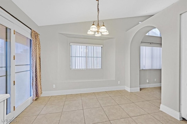 empty room featuring arched walkways, vaulted ceiling, an inviting chandelier, and light tile patterned floors