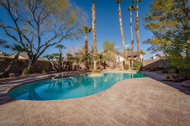 view of pool featuring a pool with connected hot tub, a fenced backyard, and a patio