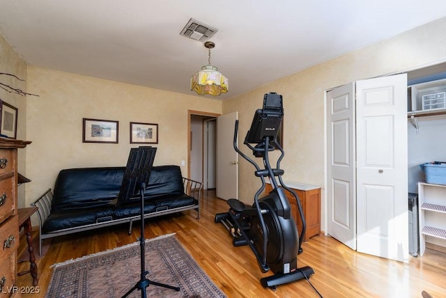 exercise room with light wood-type flooring and visible vents