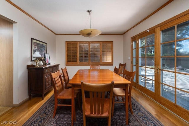 dining area featuring baseboards, french doors, ornamental molding, and light wood-style floors